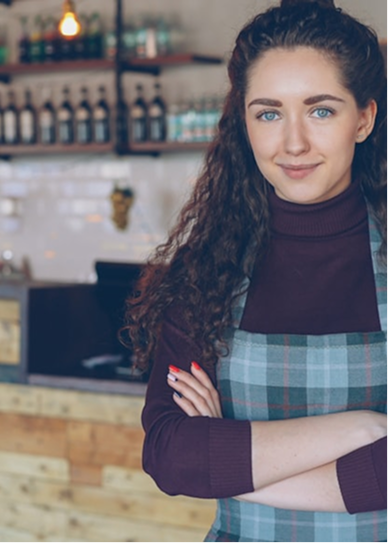 A small business owner standing behind her counter